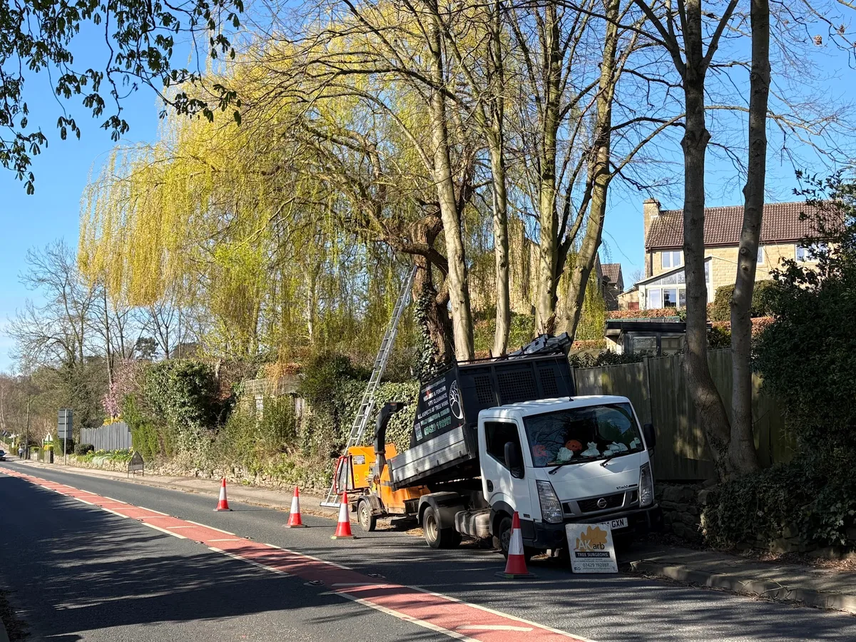 The AKarb branded truck and wood chipper beside a tree work site